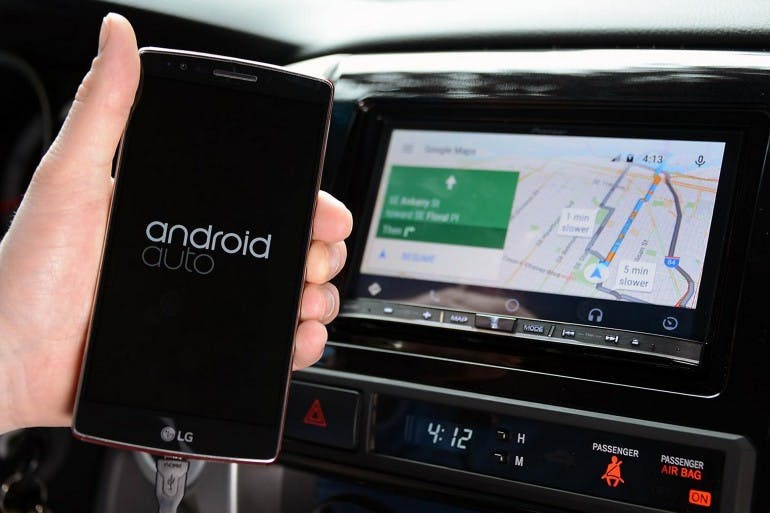 smartphone con Android Auto collegato tramite cavo all'infotainment dell'auto