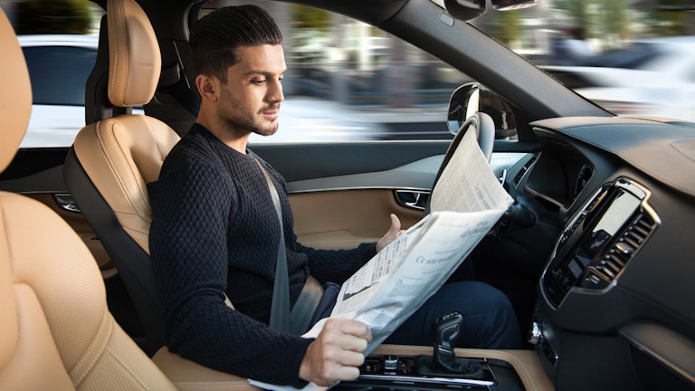 pilota che legge il giornale al volante