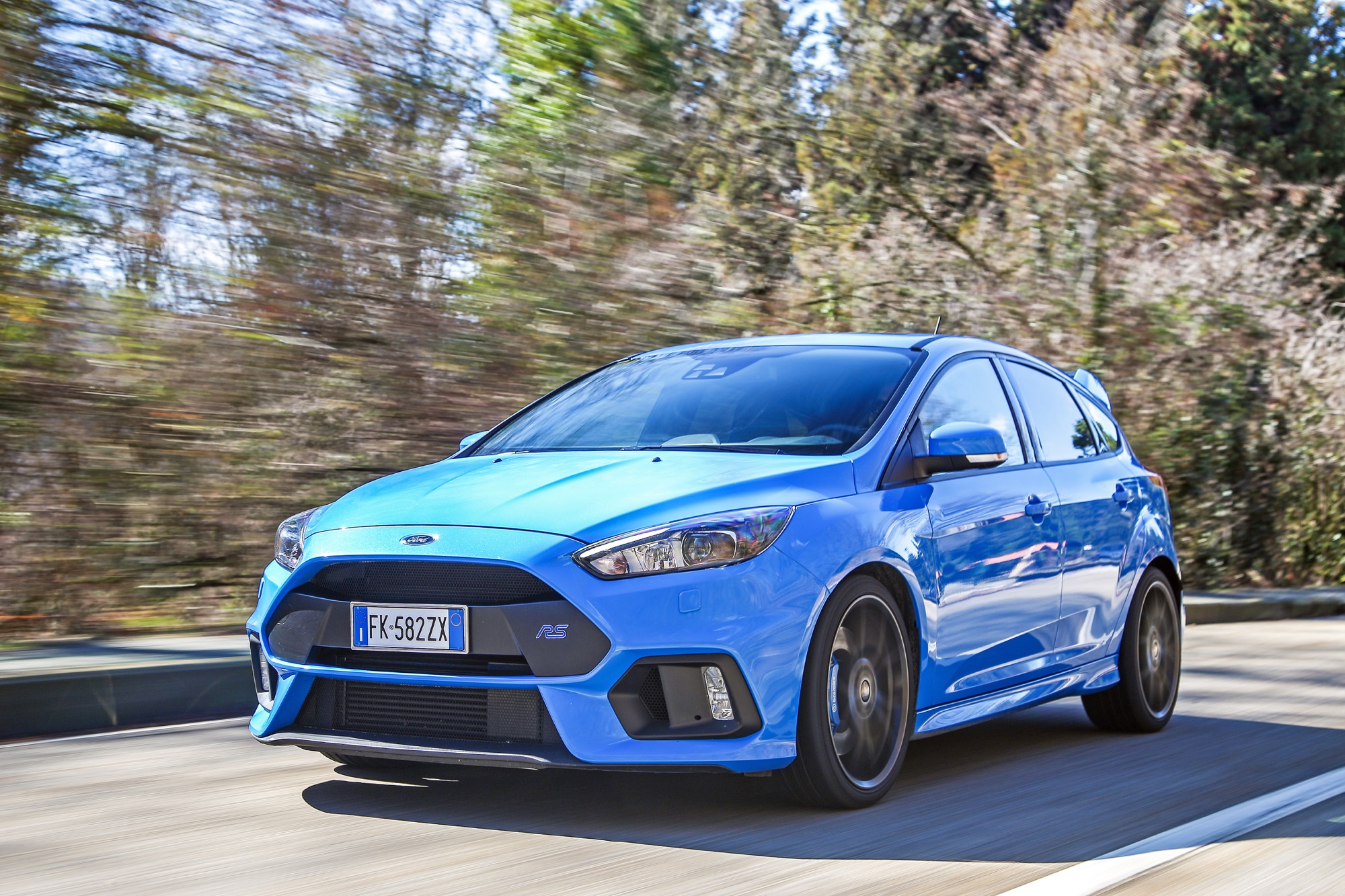 Ford Focus RS 2016 azzurro vista tre quarti anteriore viaggia in velocità con sfondo alberato