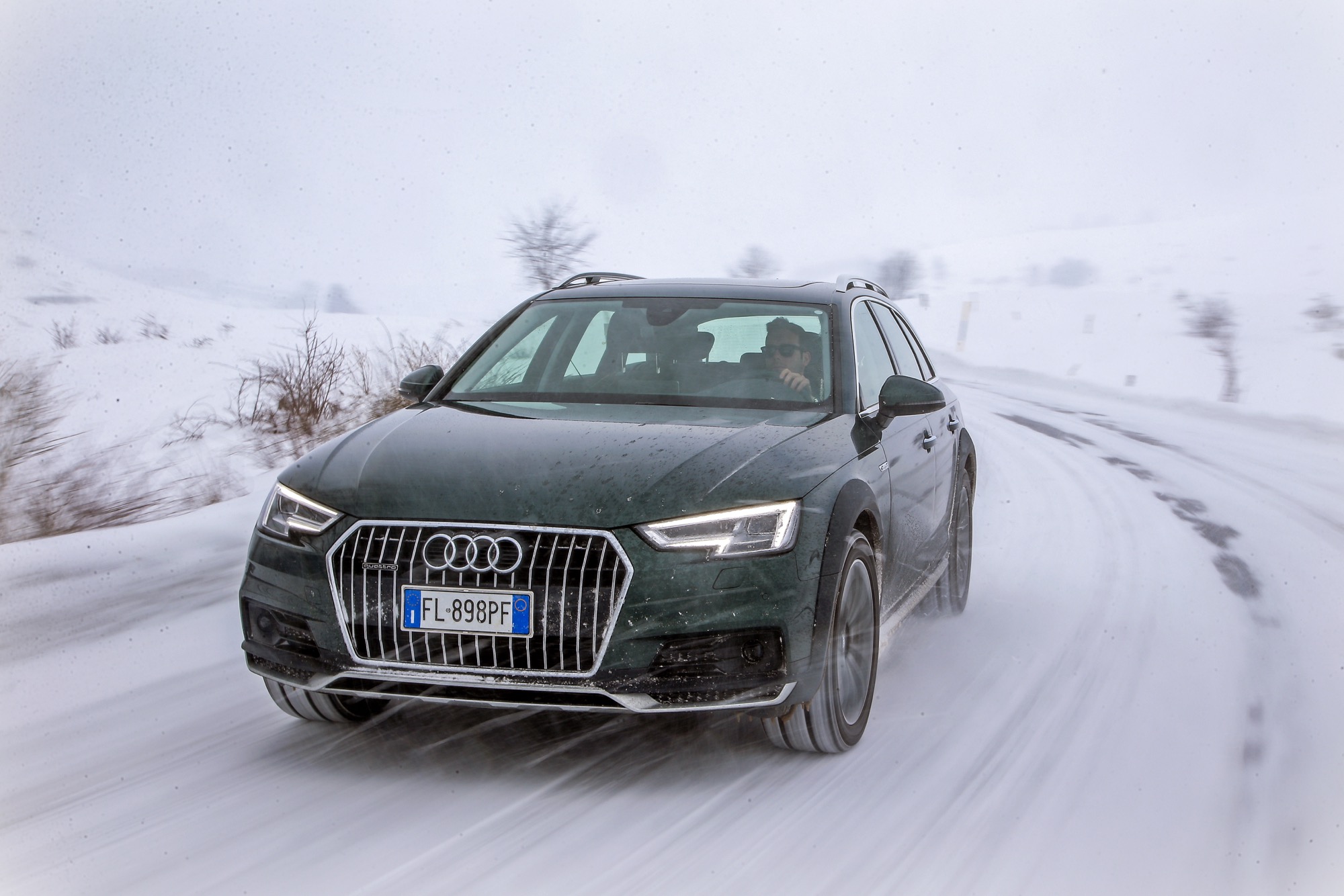 Audi A4 allroad quattro verde percorre una strada di montagna innevata
