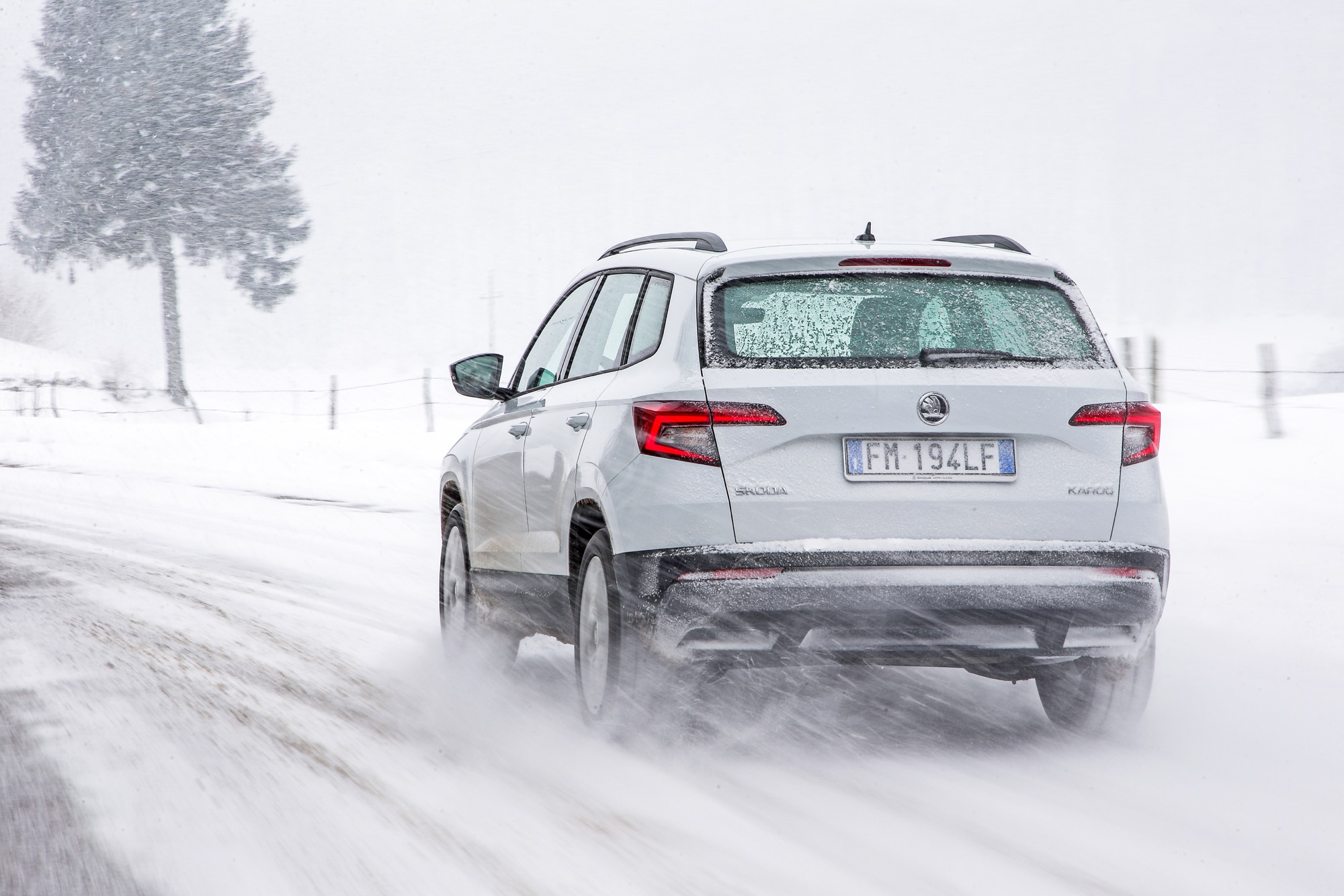 Skoda Karoq bianca vista posteriore avvolta dalla neve in sospensione