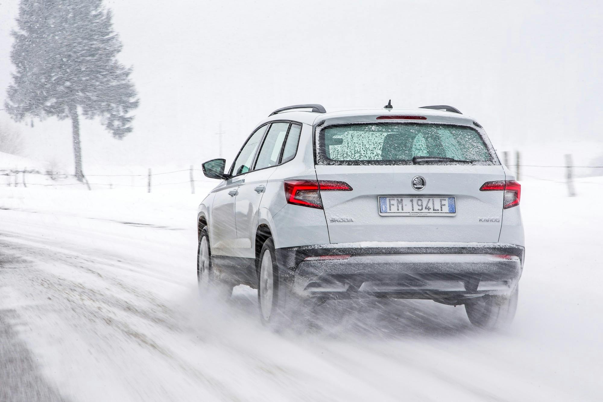 Skoda Karoq bianca vista posteriore avvolta dalla neve in sospensione