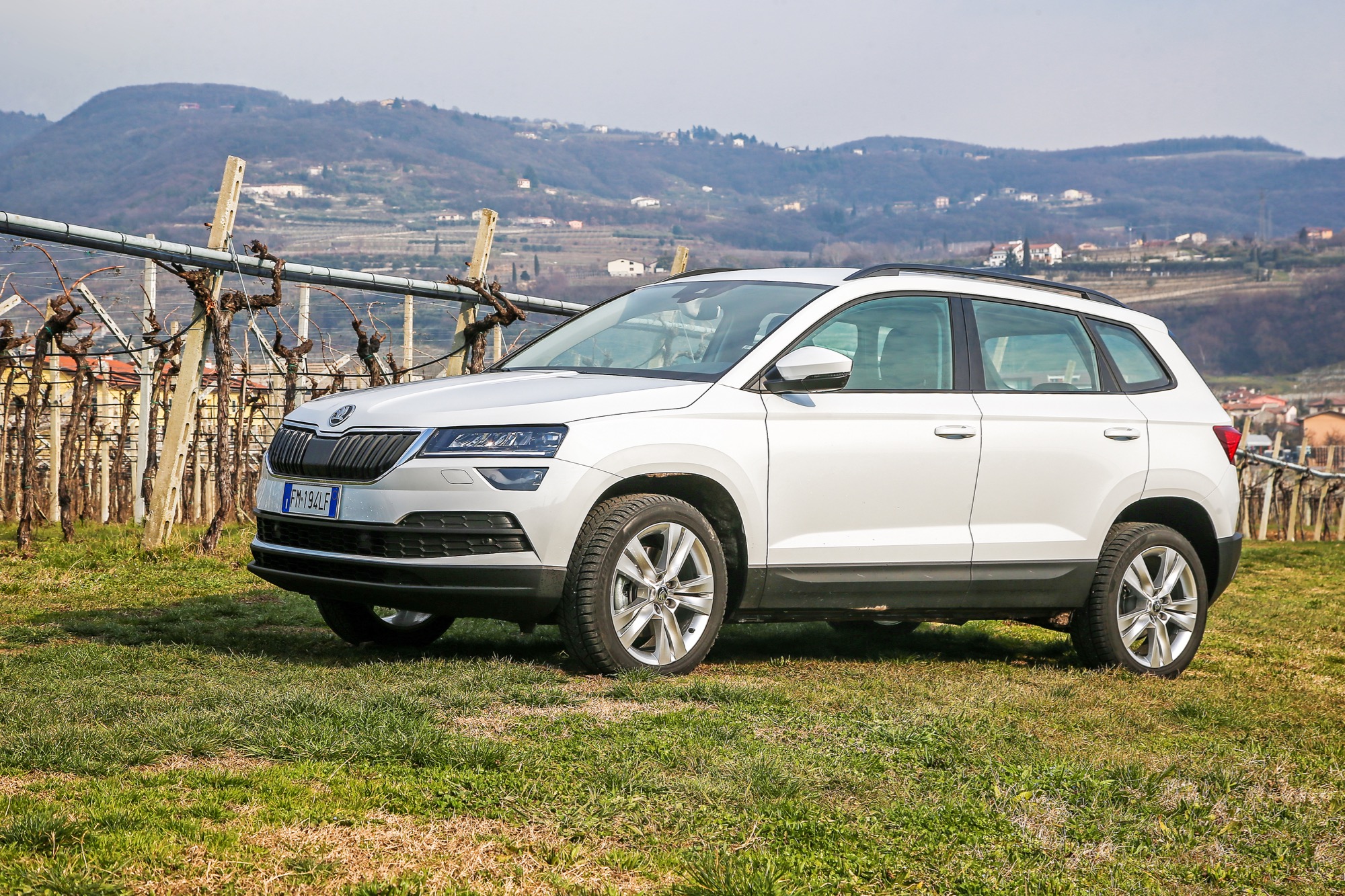 Skoda Karoq bianca statica tra i vigneti con colline di sfondo