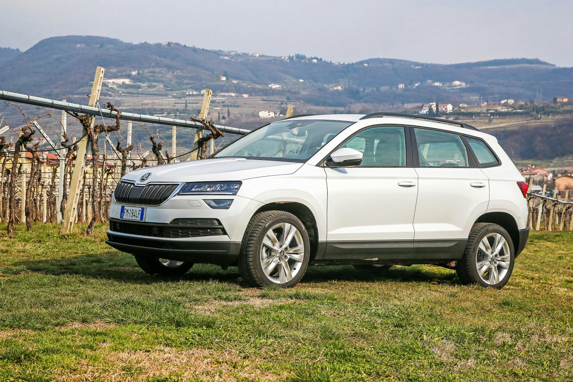 Skoda Karoq bianca statica tra i vigneti con colline di sfondo