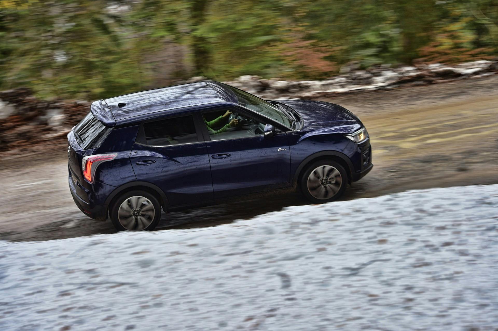Nuova SsangYong Tivoli vista laterale in movimento su strada sterrata di montagna