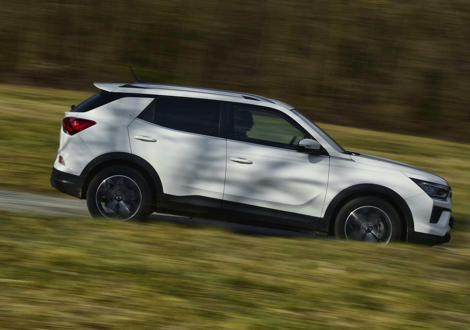 Ssangyong korando bianco vista laterale in movimento su strada