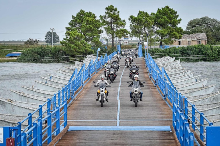 Partecipanti al Moto Guzzi Experience a bordo delle due ruote Moto Guzzi in attraversamento su ponte.