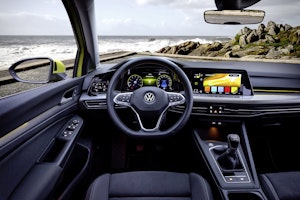 Vista centrale dell'abitacolo della nuova Volkswagen Golf 8. Dalla portiera del guidatore al tunnel centrale.