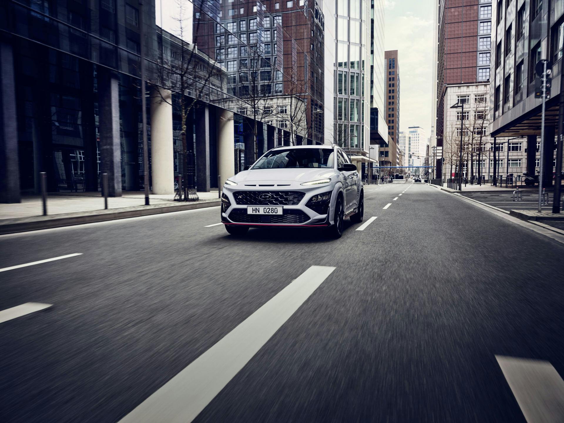 Hyundai Kona N Line vista dall'anteriore mentre percorre una strada asfaltata in ambiente urbano.