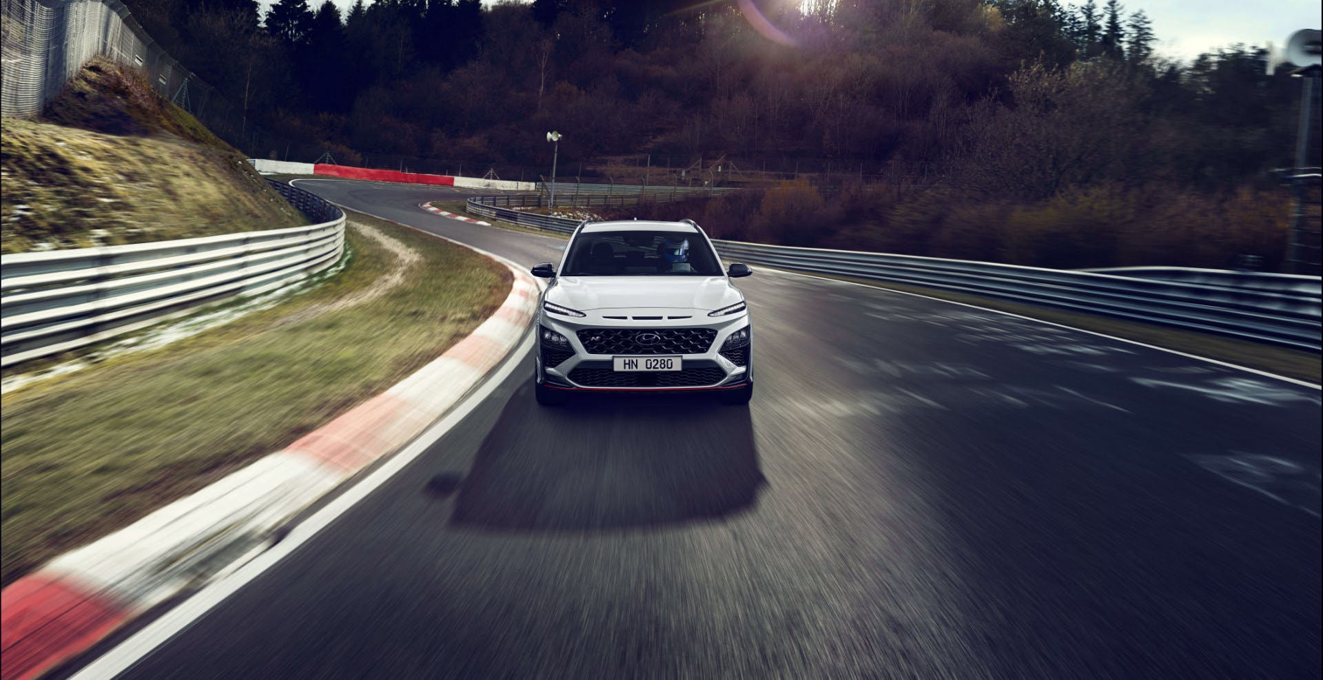 Vista frontale di Hyundai Kona N Line mentre percorre una leggera curva di un circuito