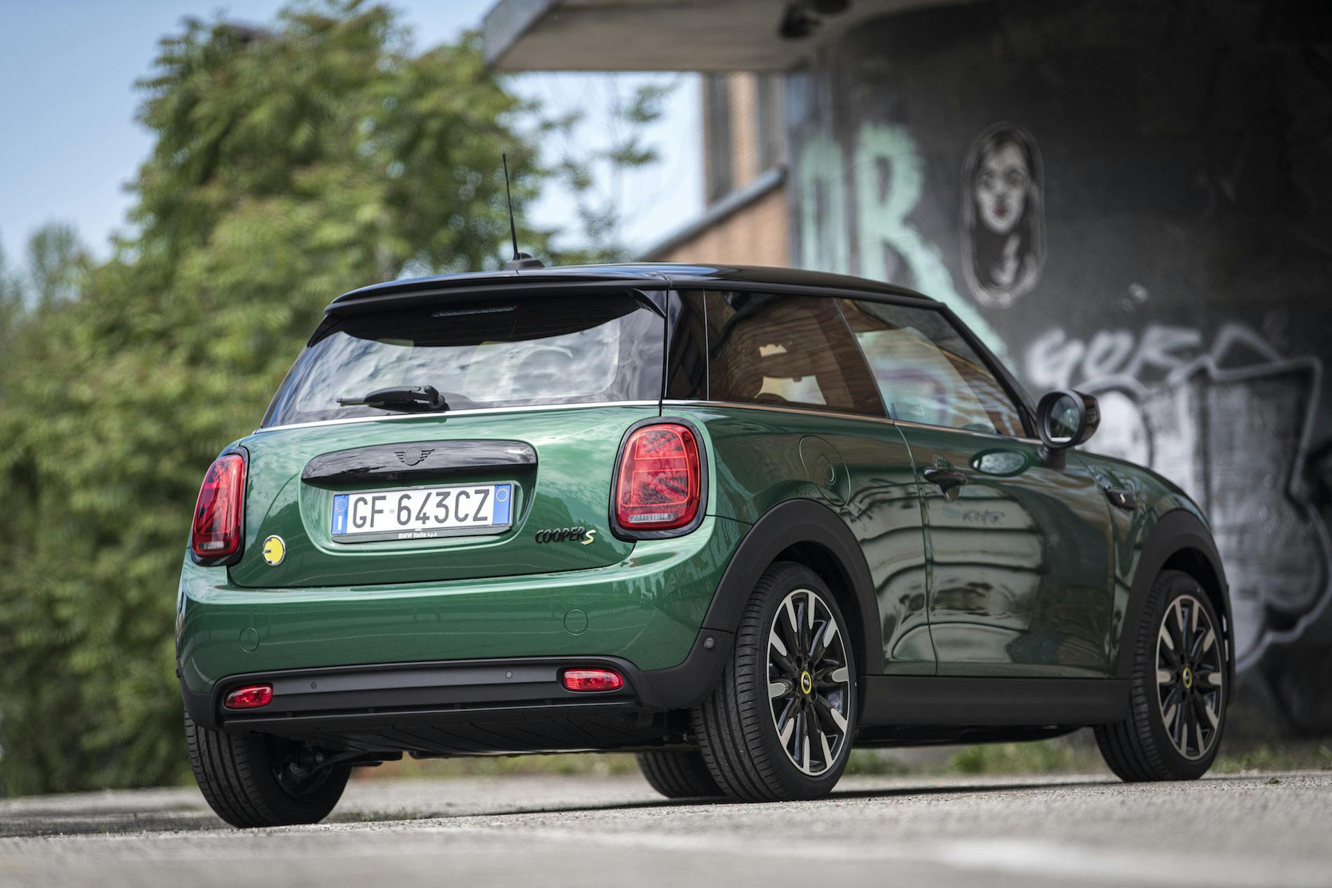 Mini Cooper SE elettrica ripresa posteriormente con murales sullo sfondo