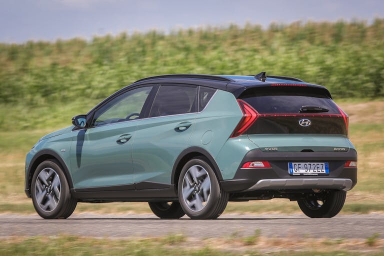 Foto dinamica di Hyundai Bayon, ripresa posteriormente di tre quarti, in ambiente extra-urbano